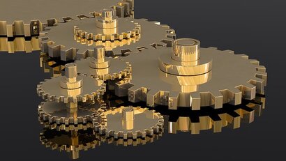 A picture of golden gears showing the importance of implementation.  All pieces must work together for the desired outcome.